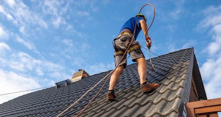man spraying roof