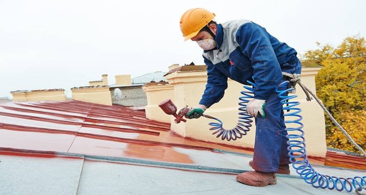man spraying roof grey